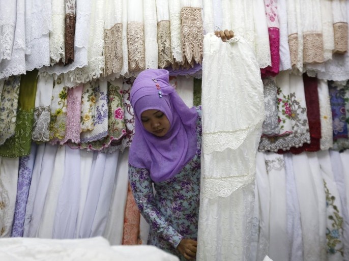 A vendor at a women's clothing stall at a traditional market waits for customers in Jakarta, Indonesia June 6, 2015. The Muslim fasting month is traditionally a time of plenty in Indonesia: shoppers throng Jakarta's markets snapping up gifts to exchange at extravagant fast-breaking celebrations. But this year, Ramadan - which runs from mid-June - will be a more abstemious affair because widespread job losses, a spike in inflation and lower earnings from commodities that Indonesia sells to the world have crimped consumers' purchasing power. REUTERS/Nyimas Laula