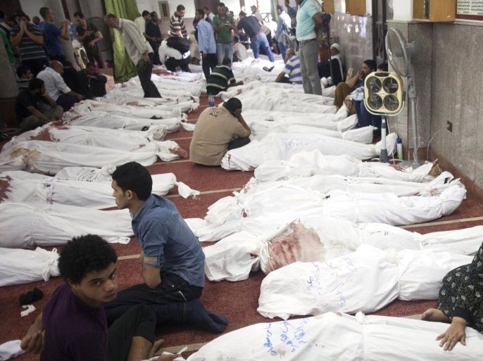 Egyptians sit next to the bodies of relatives and protesters who died following unrest the day before, at al-Imene mosque, Cairo, Egypt, 15 August 2013. At least 421 people were killed in Egypt on 14 August in violence linked to the police's break-up of two major protest camps in Cairo set up by supporters of deposed president Mohamed Morsi, the Health Ministry said. A total of 294 people were killed in Rabaa al-Adawiya in north-eastern Cairo and al-Nahda Square south