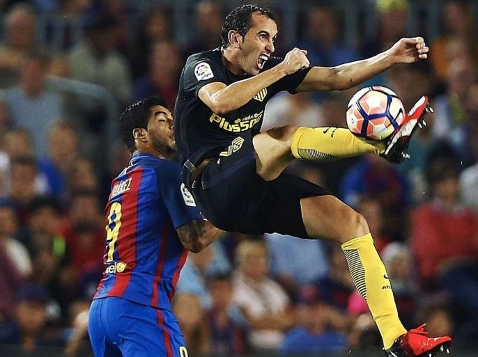 Atletico Madrid's Diego Godin (R) in action against Luis Suarez (L) of Barcelona during the Spanish Primera Division soccer match between Barcelona and Atletico Madrid at Camp Nou in Barcelona, Spain, 21 September 2016.