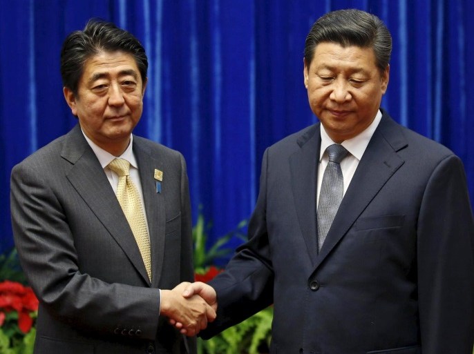 China's President Xi Jinping (R) shakes hands with Japan's Prime Minister Shinzo Abe during their meeting at the Great Hall of the People, on the sidelines of the Asia Pacific Economic Cooperation (APEC) meetings, in Beijing in this November 10, 2014 file photo. Abe in September 2015 pushed through legislation allowing Japanese troops to fight abroad for the first time since World War Two. But rather than in distant lands, it's in nearby waters that Japan's military
