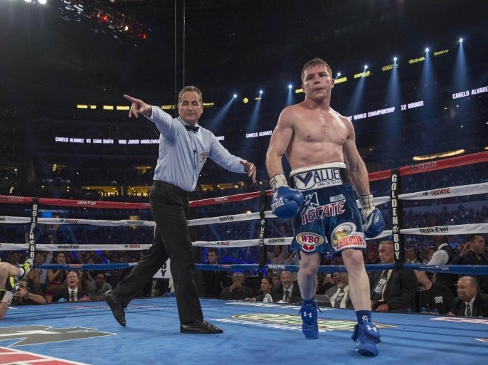 Sep 17, 2016; Arlington, TX, USA; Canelo Alvarez (blue trunks) knocks out Liam Smith (grey trunks) during the ninth round of the WBO middleweight boxing world championship bout at AT&T Stadium. Mandatory Credit: Jerome Miron-USA TODAY Sports