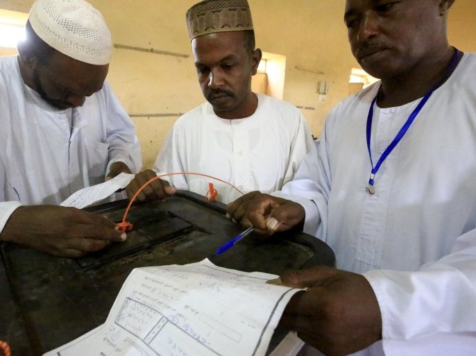 Officials check the key number before opening a ballot box to count votes after the end of general elections in Khartoum April 17, 2015. REUTERS/Mohamed Nureldin Abdallah