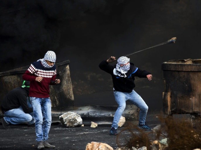 Palestinian stone throwers clashes with the Israeli army during a protest near the Israeli settlement of Beit El, near Ramallah, 16 November 2015. Clashes erupted following the funeral of two Palestinians killed by Israeli armed forces during an operation in Qalandia refugee camp to demolish the home of Mohammed Abu Shahin, accused of killing an Israeli hiker in June 2015.