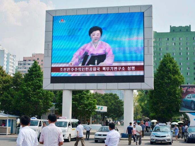 North Koreans walk past near a huge screen broadcasting the government's announcement on North Korea's fifth nuclear test in Pyongyang, North Korea, in this photo released by Kyodo September 9, 2016. Mandatory credit Kyodo/via REUTERS ATTENTION EDITORS - THIS IMAGE WAS PROVIDED BY A THIRD PARTY. EDITORIAL USE ONLY. MANDATORY CREDIT. JAPAN OUT. NO COMMERCIAL OR EDITORIAL SALES IN JAPAN.