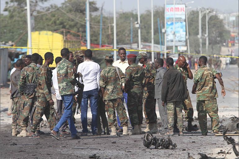 epa05545885 Somali government soldiers gather at the scene of a car bomb attack in Mogadishu, Somalia, 18 September 2016. A local report says that several people including a Somali military general and his bodyguards were killed after their convoy was hit by suspected car bomb attack in Mogadishu. Somalia's Islamist militant group Al-Shabaab often launch similar attacks in the country. EPA/SAID YUSUF WARSAME