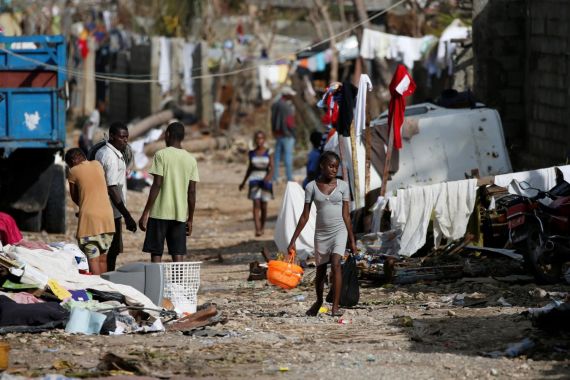 People walk down the street in front of destroyed houses after Hurricane Matthew passes Jeremie, Haiti, October 7, 2016. REUTERS/Carlos Garcia Rawlins