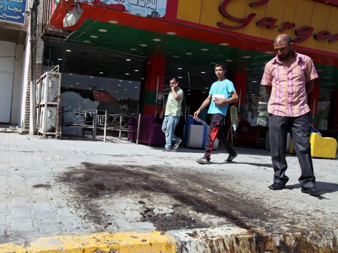 Iraqi men inspect blood stains on the ground at a scene of a suicide bomb attack at new Baghdad district in eastern Baghdad, Iraq, 09 October 2016. Three people were killed among them Shiites worshipers and others were wounded in a suicide attack that targeted a Shiite Muslims Ashura mourning procession in new Baghdad district eastern Baghdad, security officials said.