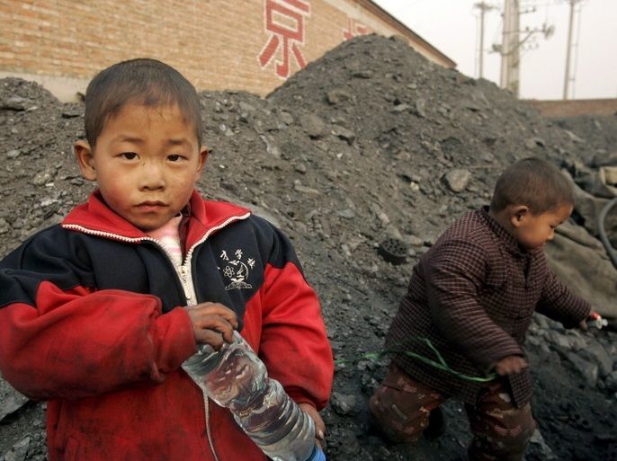 epa00889858 Children of migrant workers play on a mound of coal at a coal depository in Beijing, Thursday 21 December 2006. As coal continues to be a main source of energy, China's air pollution has become abominable with several cities having been listed as some of the most highly polluted in the world. EPA/MICHAEL REYNOLDS