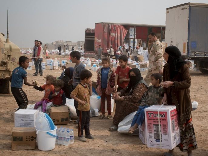 Displaced Iraqis, who fled villages south of Mosul, gather with aid supplies they received in Ibrahim Khalil village in Hamdaniyah, Iraq October 24, 2016. Picture taken October 24, 2016. UNICEF/Handout via REUTERS ATTENTION EDITORS - THIS IMAGE WAS PROVIDED BY A THIRD PARTY. FOR EDITORIAL USE ONLY.