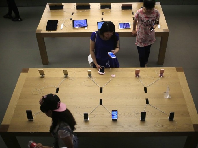 Customers looking at iPhone 6, iPhone 6 Plus and iPhone SE mobile phones in an Apple Store in Beijing, China, 17 June 2016. Apple Inc. has been ordered by Beijing's intellectual property regulator to stop sales of the iPhone 6 and iPhone 6 Plus models in the city, citing that the exterior design of the two models infringe on a Chinese patent held by Shenzhen Baili for its 100C smartphone, according to a statement on its website dated 19 May. However, the phones were st