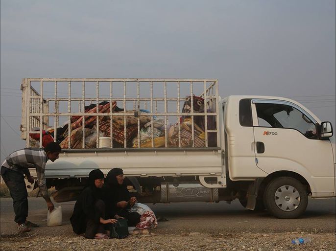 نازحون ينتظرون أمام إحدى السيارات بانتظار أن يفتح الجيش لهم الطريق للموصل إلى المناطق الآمنة