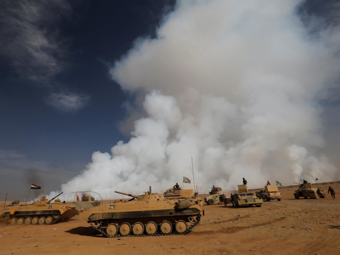 قوات عراقية بعد استعادة إحدى القرى جنوب الموصل أثناء الهجوم على تنظيم الدولة (رويترز)
