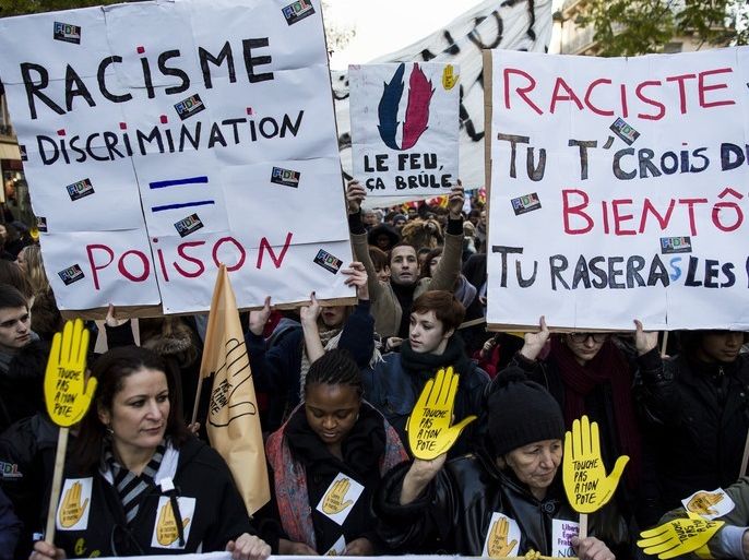 epa03971362 Demonstrators holding signs which read 'Do not touch my buddy' take part in a protest march against racism in Paris, France, 30 November 2013. Sign left reads 'Racism, discrimination - poison' and sign right reads 'Racist, you think yourself tough? soon you shall flee'. French left-wing groups and anti-racism groups, such as 'SOS-Racisme', called for anti-racist protests across France to 'block racism and extremism' following a series of racist comments made in regards to French justice minister Christiane Taubira by radical right-wing groups. EPA/IAN LANGSDON