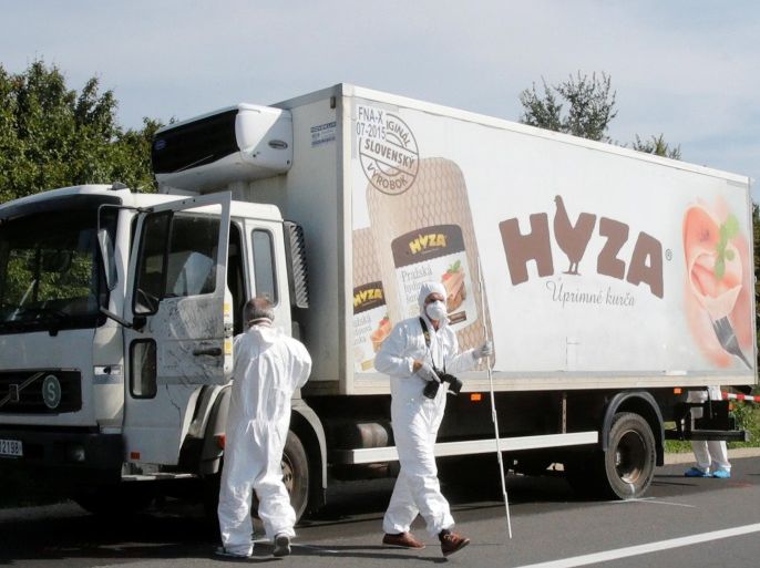 Forensic police officers inspect a parked truck in which up to 50 migrants were found dead, on a motorway near Parndorf, Austria August 27, 2015. REUTERS/Heinz-Peter Bader/File photo