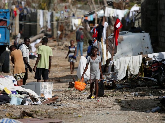 People walk down the street in front of destroyed houses after Hurricane Matthew passes Jeremie, Haiti, October 7, 2016. REUTERS/Carlos Garcia Rawlins