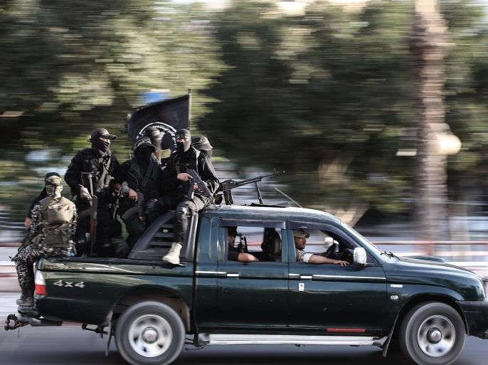 Fighters of Islamic Jihad militants ride on the back of a car with their weapons during their military march in the streets of Gaza City, 19 October 2016.
