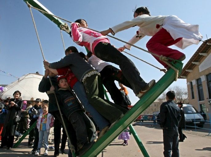 epa00676877 Local children enjoy the holiday of Navruz, the muslim new year, at the central square of the town of Baikonur in western Kazakhstan, Saturday 25 March 2006. Last year cosmodrome Baikonur, a former Soviet secret military base, marked its 50th anniversary. EPA/SERGEI CHIRIKOV