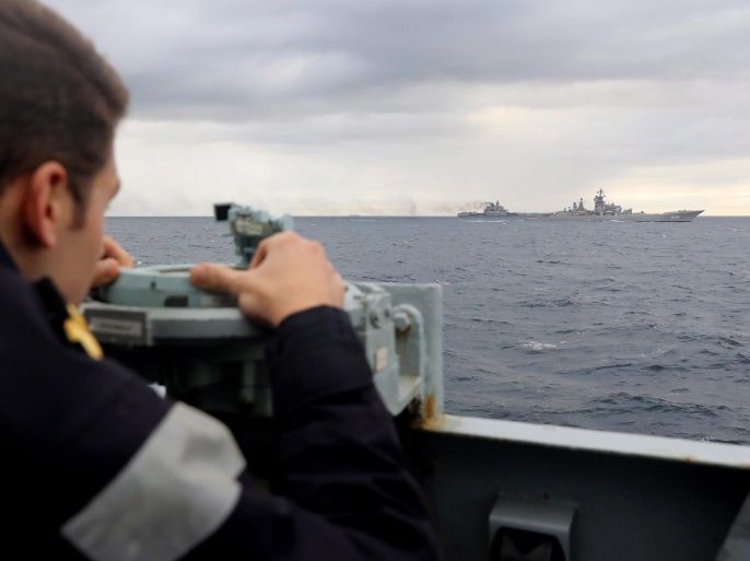 A handout photograph made available by the British Ministry of Defence showing British Royal Navy lookout, observing the Russian task group during transit from the British Royal Navy, HMS Richmond, a Type 23 Duke Class frigate, shadowing Russian aircraft carrier Admiral Kuznetsov (L) part of the Russian Task Force Carrier Group, sailing south from the Norwegian Sea, on 19 October 2016 which is understood to be on transit to the Mediterranean Sea. At present the route wh