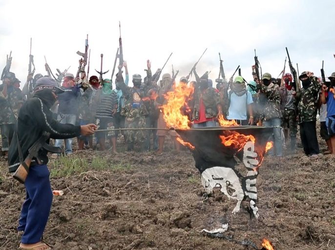 A picture made available on 20 January 2016 shows Filipino members of the armed Christian group calling themselves 'Red Gods Defenders' burning a replica of the so-called Islamic State (ISIS or IS) flag in the mountains of Central Mindanao, Philippines, 19 January 2016, to show their opposition over a plan of the jihadist militant group of putting up their own territory in the restive area of the country. According to news reports, ISIS sees the Philippines as a poten