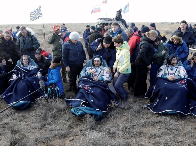 The International Space Station (ISS) crew members Kate Rubins of the U.S., Anatoly Ivanishin of Russia and Takuya Onishi of Japan, surrounded by ground personnel, rest shortly after landing of the Russian Soyuz MS space capsule near the town of Dzhezkazgan (Zhezkazgan), Kazakhstan, October 30, 2016. REUTERS/Dmitri Lovetsky/Pool