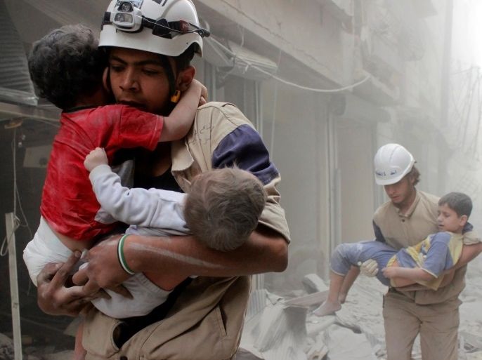 Members of the Civil Defence rescue children after what activists said was an air strike by forces loyal to Syria's President Bashar al-Assad in al-Shaar neighbourhood of Aleppo, Syria June 2, 2014. REUTERS/Sultan Kitaz/File Photo TPX IMAGES OF THE DAY