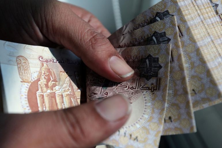 A man counts Egyptian pounds outside a bank in Cairo, Egypt October 24, 2016. Picture taken October 24, 2016. REUTERS/Mohamed Abd El Ghany