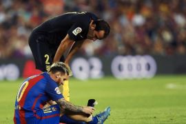 Atletico Madrid's Diego Godin next to FC Barcelona's Lionel Messi sitting on the turf after he picked up an injury during the Spanish Primera Division soccer match between Barcelona and Atletico Madrid at Camp Nou in Barcelona, Spain, 21 September 2016.