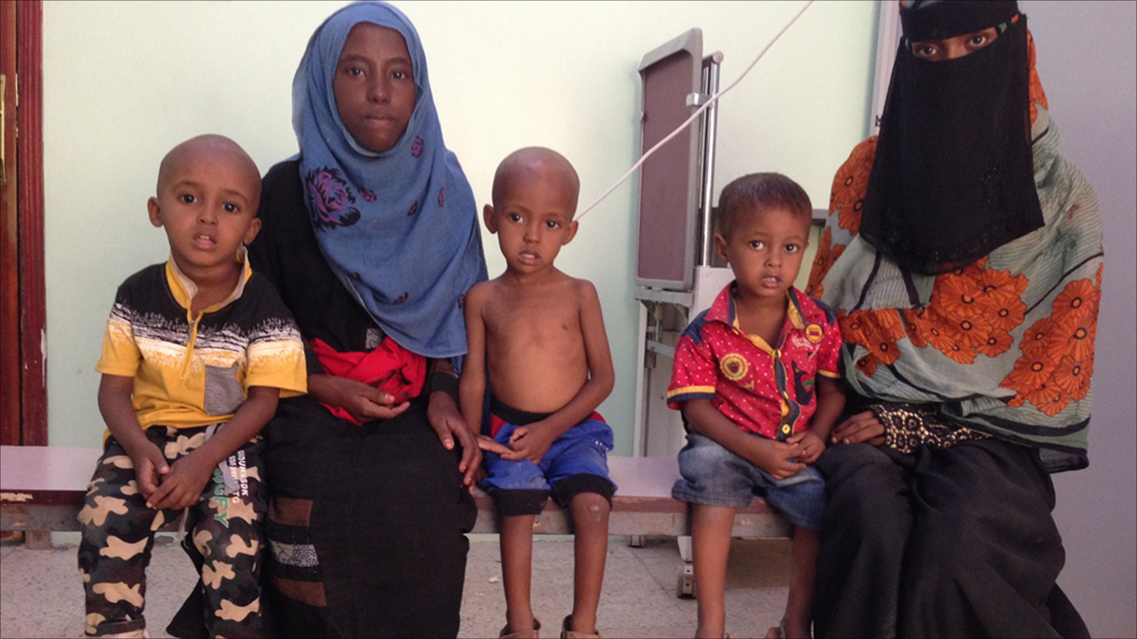 فطوم أويس (يمين) مع ابنها وعدد من الأطفال في مركز طبي لتلقي العلاج من سوء التغذية (الجزيرة)