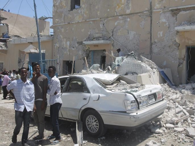 People gather at the scene of a suicide car bomb attack near the Presidential palace in the capital Mogadishu, Somalia, 30 August 2016. Reports say at least several people, including the government soldiers, were killed when a suicde bomber detonated a car bomb near the presidential palace. Somalia's Islamist militant group al-Shabab has claimed responsibility for the latest attack.