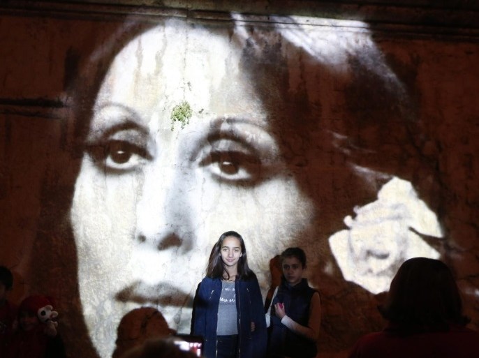 A family of Baalbek residents take picture next to the image of the Lebanese singer Fairuz lighting the columns of Baalbek structures and listen to her most beautiful songs during an honoring ceremony for the Lebanese singer Fairuz to mark the 81st birthday gala in the city of Baalbek, in eastern Lebanon, 21 November 2016.