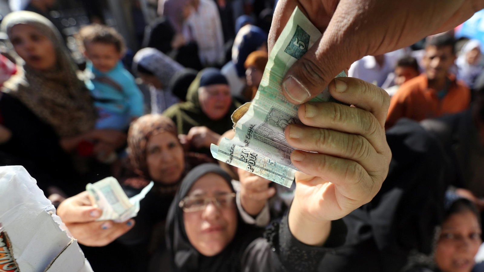 مصريون يتجمعون لشراء السكر والزيت من شاحنة حكومية (رويترز)
