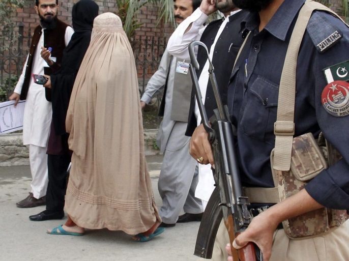 Pakistani security officials escort Afghan refugee woman Sharbat Gula (C, in burqa), after a medical examination at a hospital before she was presented to a court in Peshawar, Pakistan, 04 November 2016. A Pakistani court in Peshawar city had on 02 November refused bail to Gula, who has been detained for allegedly possessing a fake identity card. She was arrested on 26 October for allegedly obtaining Pakistani identity documents for herself and her two children after bribing three officials, charges that could land her a 14-year jail sentence. Sharbat Gula became famous by the photographic portrait 'Afghan Girl' taken of her with her striking green eyes by photographer Steve McCurry and published on the cover of the 'National Geographic' in June 1985.