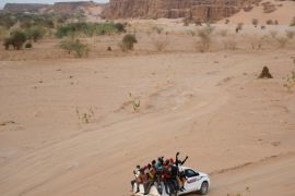 Migrants crossing the Sahara desert into Libya ride on the back of a pickup truck outside Agadez, Niger, May 9, 2016. Picture taken May 9, 2016. REUTERS/Joe Penney