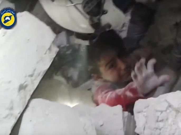 A handout frame grab from video footage released on 17 November 2016 by the Syrian Civil Defense, also known as the White Helmets, showing rescuers trying to pull out a child trapped under the rubbles of a building at Maadi neighborhood, Aleppo, Syria. No further details were given on the incident. According to monitors and rescue groups, airstrikes and artillery fire, reportedly by forces loyal to the Syrian government, continued over the rebel-held neighborhoods of Al
