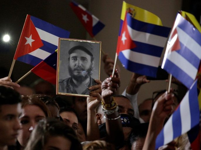 A portrait of the late former Cuban leader Fidel Castro is seen among Cuban and Venezuelan flags during his homage ceremony at the 4F military fort in Caracas, Venezuela November 26, 2016. REUTERS/Marco Bello