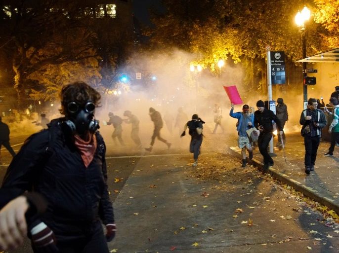 People try to move away from a gas cloud during a protest against the election of Republican Donald Trump as President of the United States in Portland, Oregon, U.S. November 12, 2016. REUTERS/William Gagan FOR EDITORIAL USE ONLY. NO RESALES. NO ARCHIVES
