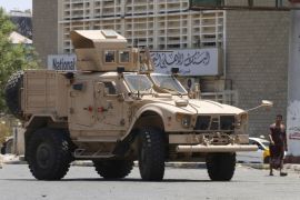 People walk past a military vehicle from the Saudi-led coalition stationed near a government bank in Yemen's southern port city of Aden September 27, 2015. As Gulf-backed forces assemble in Marib province east of Sanaa ahead of a widely expected thrust towards the Houthi-held capital, the fate of Aden and its hinterland may offer a glimpse at whether some form of central government can be resurrected. To match Insight YEMEN-SECURITY/ADEN REUTERS/Faisal Al Nasser