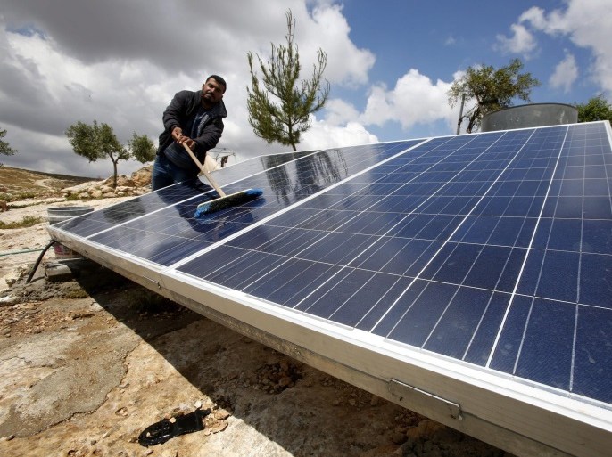 A member of the al-Hamadeh family cleans solar power plats outside a cave they use as their home on the outskirts of the West Bank village of Mufagra, in Yatta, 80 kilometers south of Hebron, 14 April 2016. Residents claim that they have received a orders from the Israeli army banning them from building houses or roads in the area. According to the family's elders they have been living in this area already for 200 to 300 years and their living depends on their cattle.