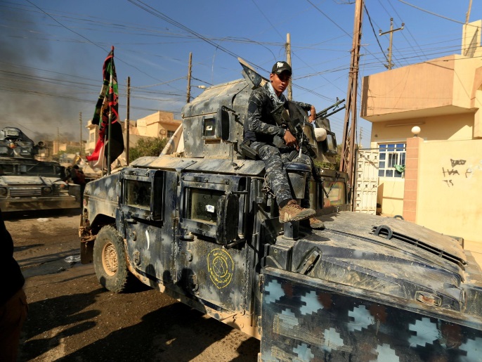 أحد أفراد القوت العراقية فوق مركبة عسكرية بحمام العليل جنوب الموصل أمس الأحد (رويترز) 