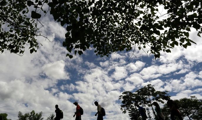 Immigrants walk toward the premises of a group called "Las Patronas" (The bosses), a charitable organization that feeds Central American immigrants on their way to the border with the United States who travel atop a freight train known as "La Bestia", in Amatlan de los Reyes, in Veracruz state, Mexico October 22, 2016. Picture taken October 22, 2016. REUTERS/Daniel Becerril