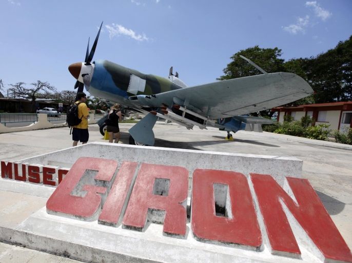 Tourists look at a British-made Sea Fury fighter plane used by revolutionary troops displayed at the Giron War Museum near the Bay of Pigs in the Zapata swamp April 8, 2012. On April 17, 1961, a force of CIA-trained Cuban exiles, backed by U.S. ships and planes, came ashore at the Bay of Pigs 100 miles (160 km) southeast of Havana in a bloody attempt to spark a counter-revolution. Cuban leader Fidel Castro rallied tens of thousands of troops and citizens to the battle and two days later, on April 19, 1961, declared victory as the attackers fled or were killed or captured in the botched invasion. Picture take April 8, 2012. REUTERS/Desmond Boylan (CUBA - Tags: SOCIETY ANNIVERSARY MILITARY POLITICS)