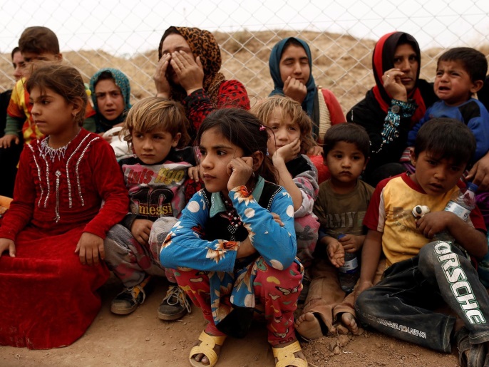 ‪بعض العائلات تنتظر استلامها خياما للسكن لحظة وصولها إلى مخيم الخازر‬ (رويترز)