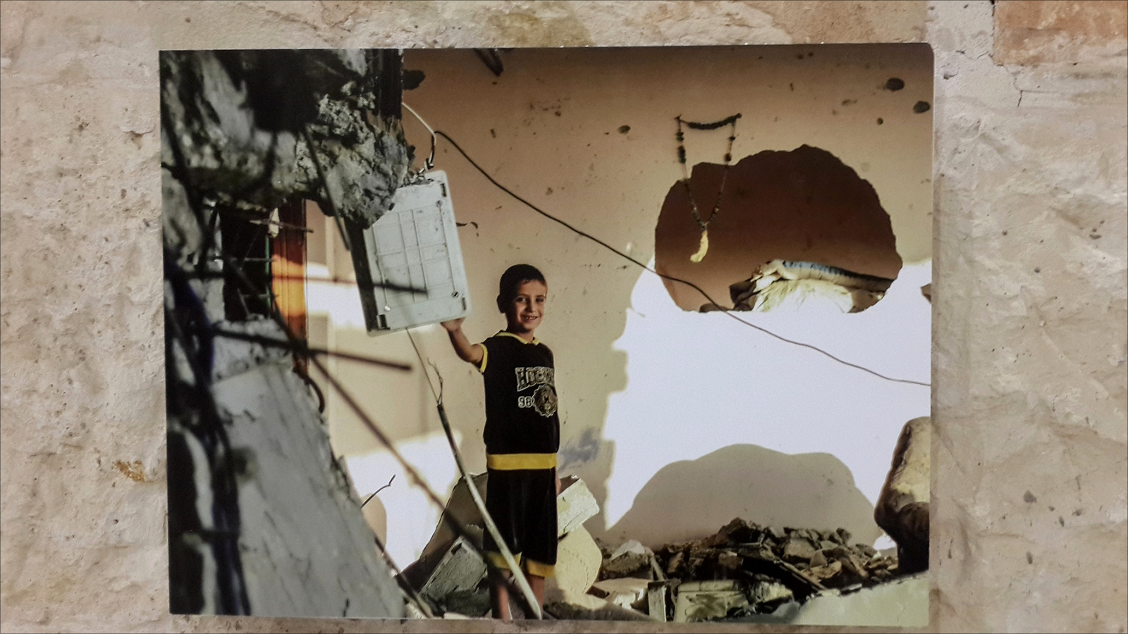 صورة لطفل غزي داخل منزله المدمر بعد عامين من الحرب(الجزيرة)