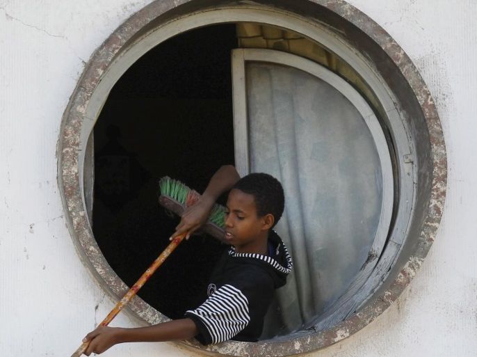 A boy cleans the outside of the Bar Zilli building on Beirut Street in Eritrea's capital Asmara, February 20, 2016. Eritrea's capital city boasts one of the world's finest collections of early 20th century architecture, which the authorities want declared a UNESCO World Heritage Site. When Italy's colonial experiment in Eritrea ended in 1941, it left behind an array of Rationalist, Futurist, Art Deco and other styles of Modernism in Asmara, a city they nicknamed "La