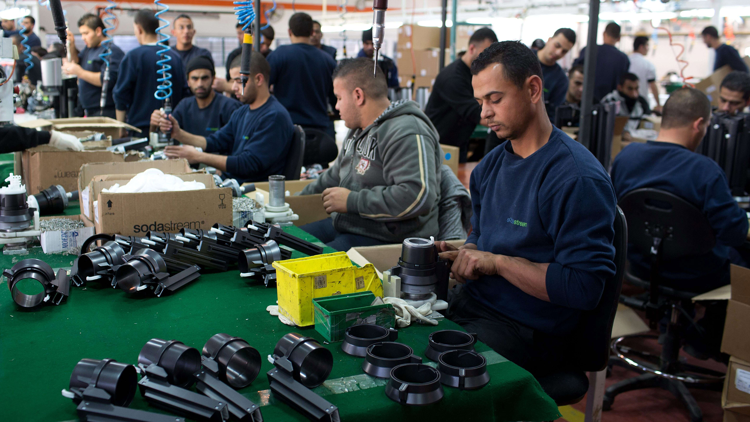 فلسطينيون يعملون في مصنع إسرائيلي قرب مستوطنة معاليه أدوميم بالضفة الغربية (الفرنسية)