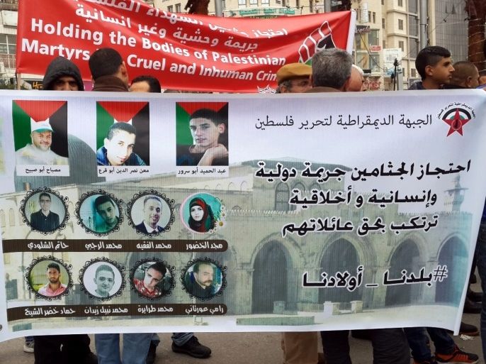 فلسطين رام الله 28 ديسمبر 2016 نشطاء فلسطينيون يحملون ملصقا بصور 11 شهيدا فلسطينيا لا زال الاحتلال يحتجز جثامينهم منذ شهور