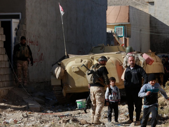 مدنيون يلتمسون مكانا آمنا هربا من اشتباكات بين جنود عراقيين ومسلحي تنظيم الدولة جنوب الموصل