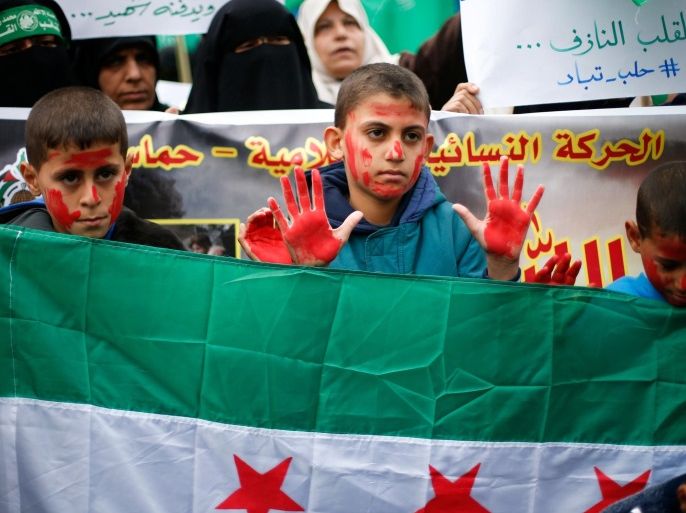 A Palestinian boy covered with ink gestures during a protest to show solidarity with trapped citizens of Aleppo, Syria, in Gaza city December 15, 2016. REUTERS/Suhaib Salem