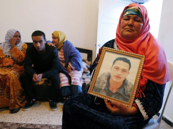 epaselect epa05685591 Nour Al Houda (R), 65, poses with a portrait of her son Anis Amri who is subject of an European arrest warrant in relation with the 19 December truck attack on a Christmas market in Berlin, in her home in Oueslatia, Tunisia, 22 December 2016. Anis Amri is the prime suspect of being the truck driver in the attack. At least 12 people were killed and dozens injured when a truck on 19 December drove into the Christmas market at Breitscheidplatz in Berl