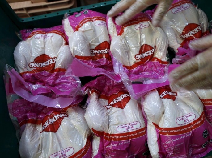 A worker arranges vacuum-packed chickens to be blast frozen at Kee Song Brothers' poultry slaughterhouse in Singapore April 27, 2015. In barns filled with classical music and lighting that changes to match the hues outside, rows of chickens are fed a diet rich in probiotics, a regimen designed to remove the need for the drugs and chemicals that have tainted the global food chain. Picture taken April 27, 2015. To match POULTRY-DRUG/ REUTERS/Edgar Su